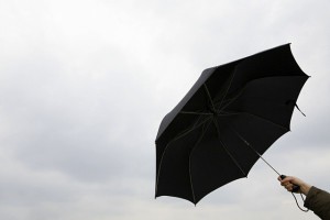 Person holding black umbrella against the rain --- Image by © Image Source/Corbis